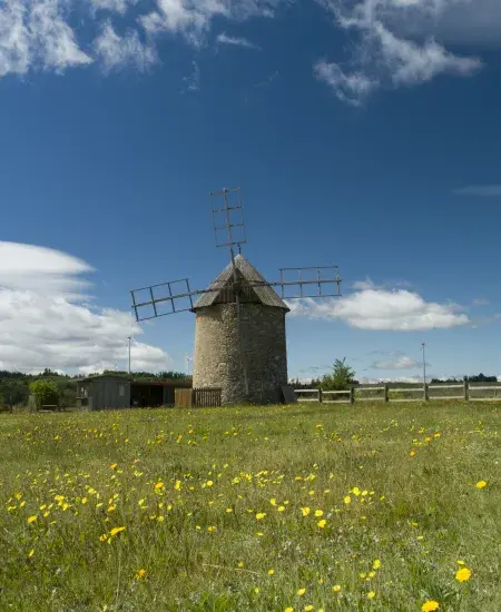 Moulin devant les éoliennes du Plateau d'Ally-Mercoeur en France