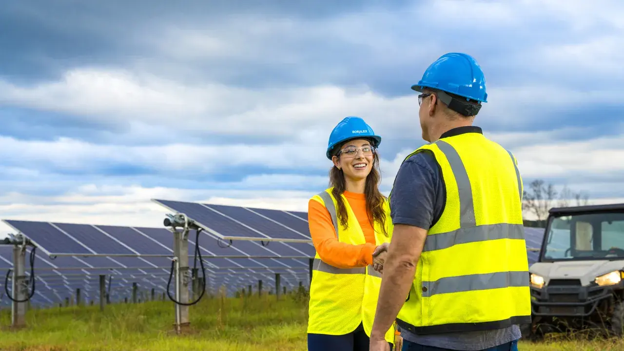 Two persons shaking hands on a solar site, North America